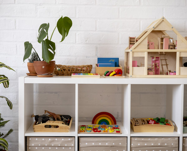 Wooden toys are shown on a shelving unit.