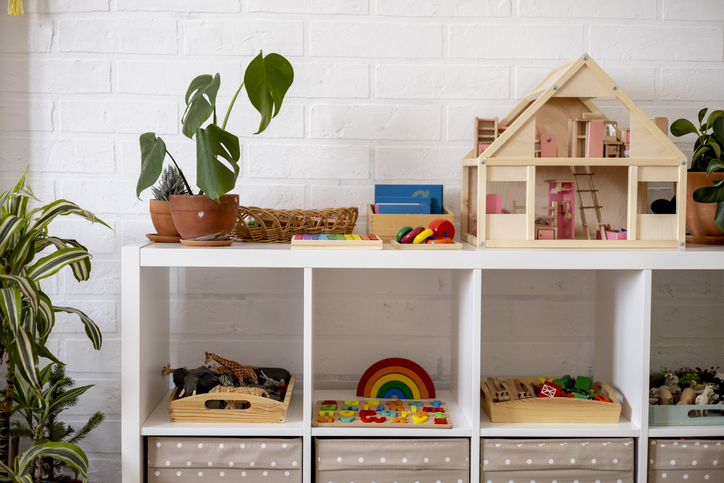 Wooden toys are shown on a shelving unit.