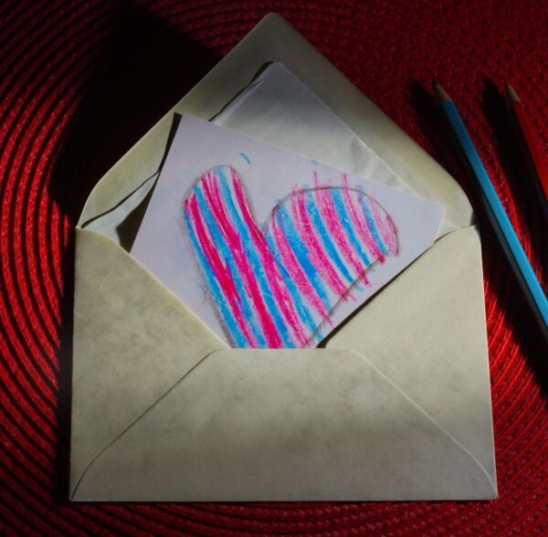 Image shows a picture of a blue and pink heart in an envelope.