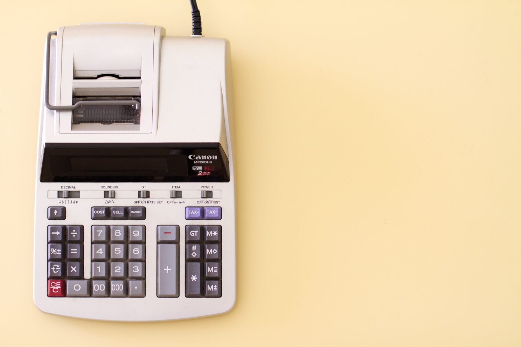 An accounting calculator is shown on a cream background.