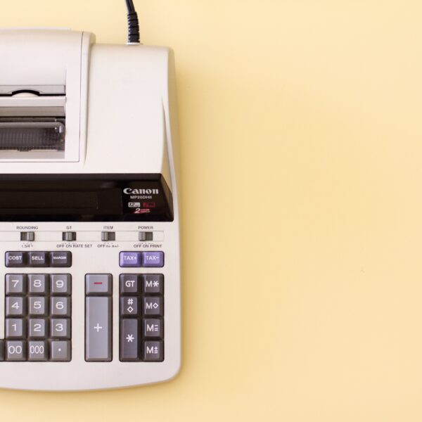 An accounting calculator is shown on a cream background.