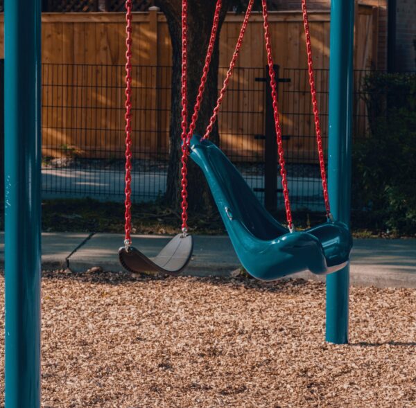 Empty swings are shown in a children's park